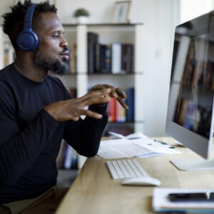 Man with headphones having video call at home office